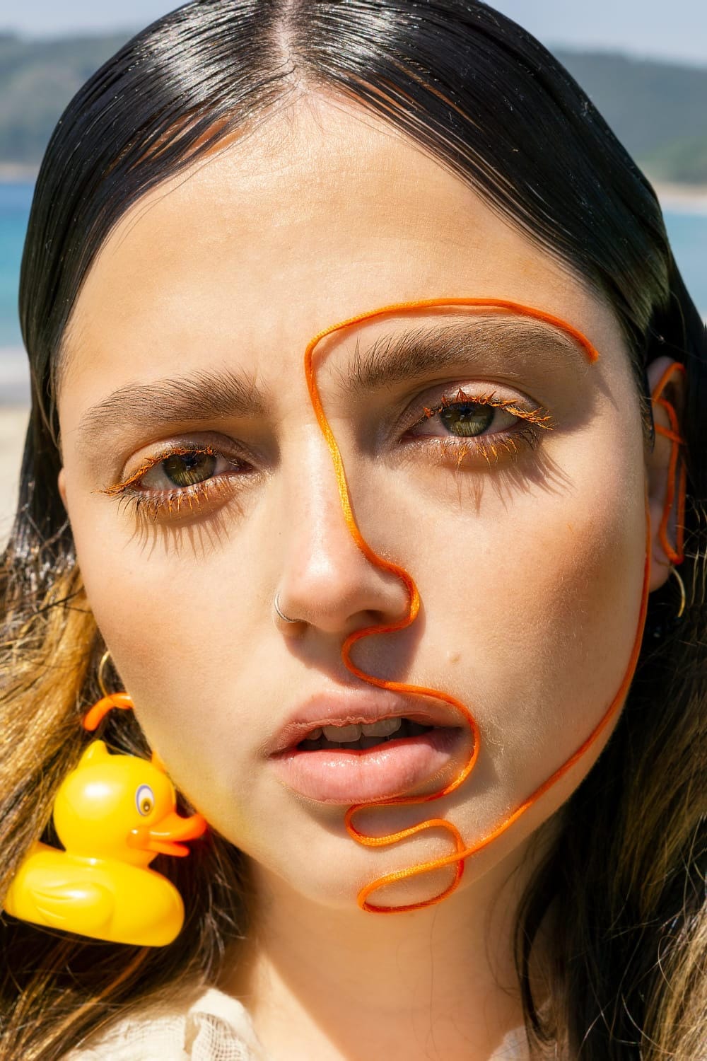 rostro de modelo con hilo naranja