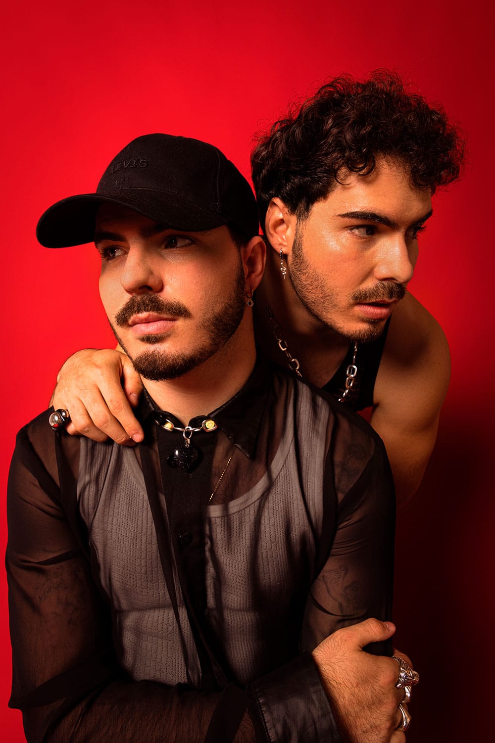 gemeliers posando sobre fondo rojo